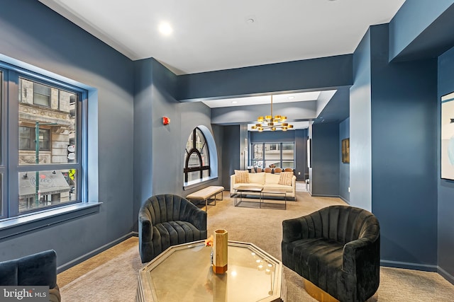 living area featuring a notable chandelier, carpet flooring, and a tray ceiling