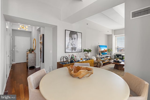 dining area with dark hardwood / wood-style floors and a notable chandelier