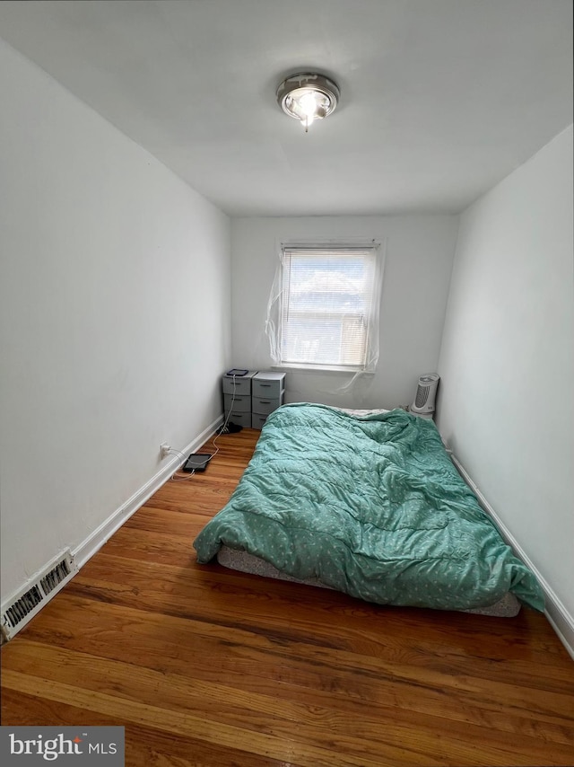 bedroom with dark wood-type flooring