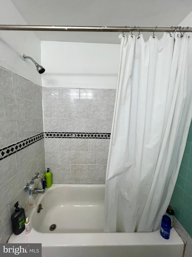 bathroom featuring tile walls and shower / bath combo