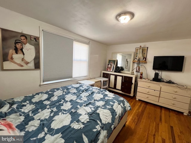 bedroom with dark hardwood / wood-style floors