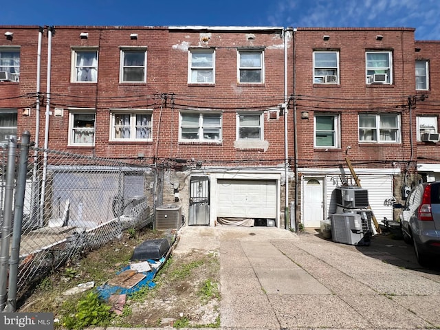 view of front of house with a garage and central air condition unit