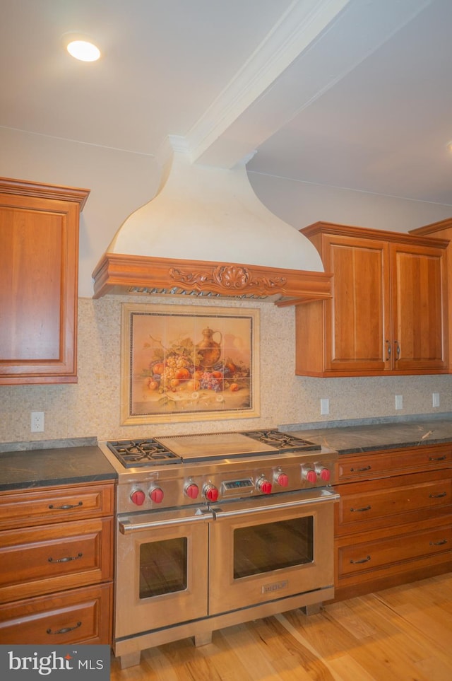 kitchen featuring backsplash, light hardwood / wood-style flooring, double oven range, and custom range hood