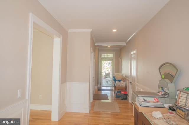 hall with light hardwood / wood-style floors and ornamental molding