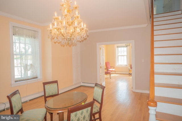 dining space featuring baseboard heating, light hardwood / wood-style flooring, a notable chandelier, and ornamental molding