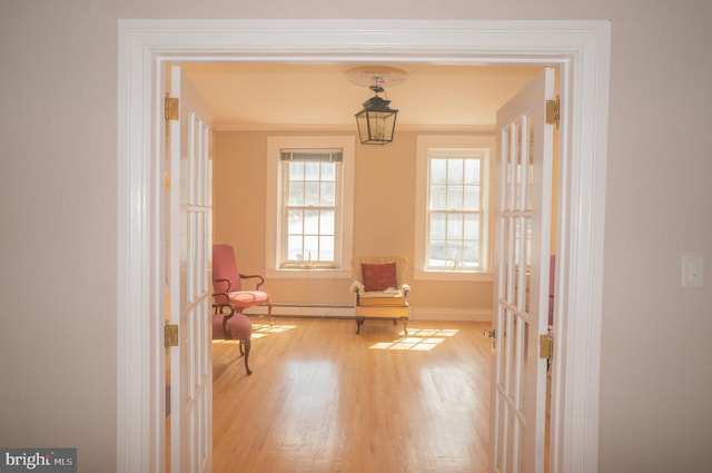 sitting room with french doors, light hardwood / wood-style floors, and ornamental molding