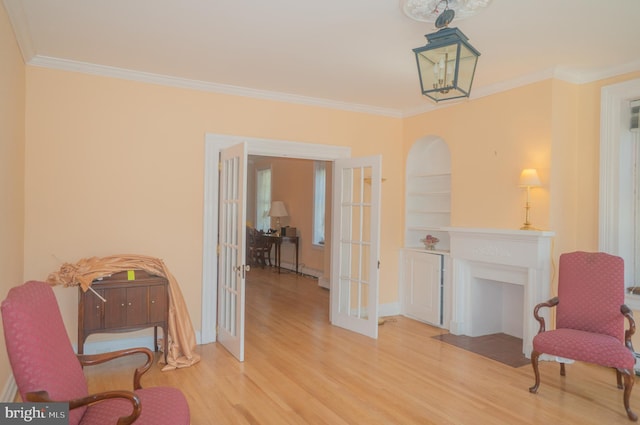 living area featuring french doors, light hardwood / wood-style flooring, and ornamental molding