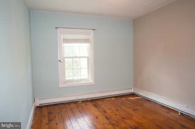 unfurnished room featuring hardwood / wood-style flooring and baseboard heating