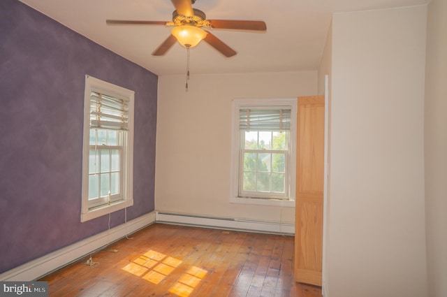 spare room featuring hardwood / wood-style flooring, ceiling fan, and a baseboard radiator