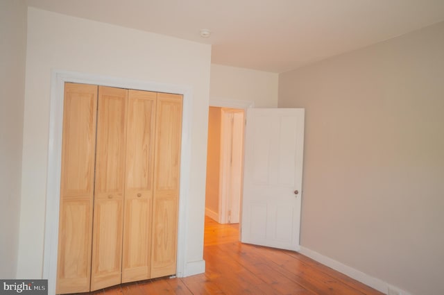 unfurnished bedroom featuring light hardwood / wood-style floors and a closet