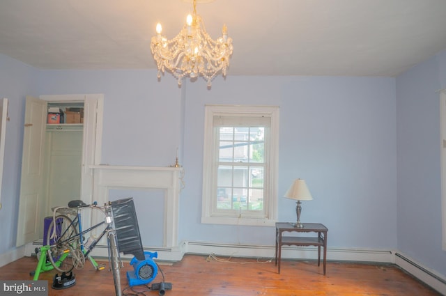 miscellaneous room featuring a chandelier, hardwood / wood-style flooring, and a baseboard heating unit