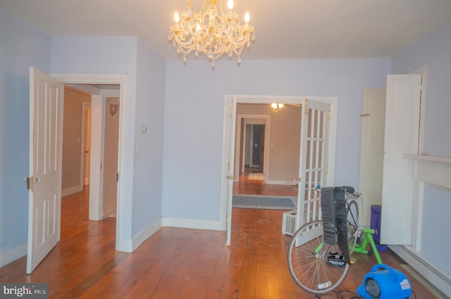 unfurnished dining area featuring wood-type flooring and an inviting chandelier