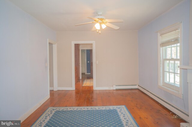 spare room with ceiling fan, light hardwood / wood-style floors, and a baseboard heating unit