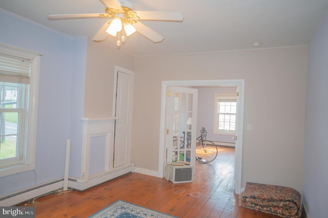 unfurnished room featuring ceiling fan, hardwood / wood-style floors, and a baseboard radiator