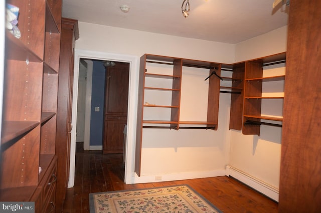 walk in closet with dark hardwood / wood-style flooring and a baseboard radiator