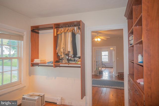 interior space with a wall unit AC, ceiling fan, and hardwood / wood-style floors