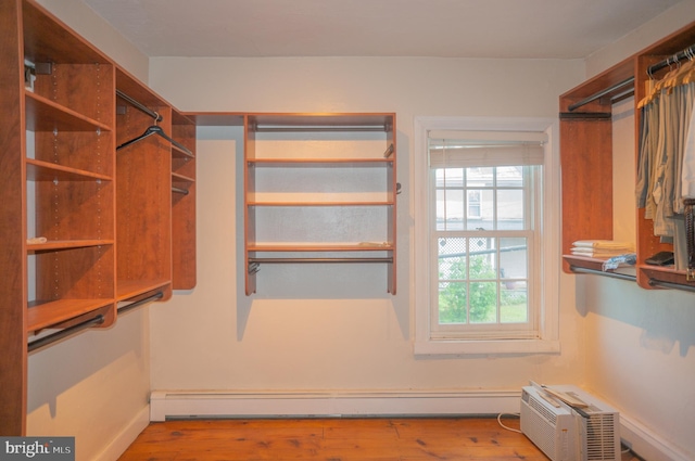 spacious closet with light wood-type flooring and a baseboard heating unit