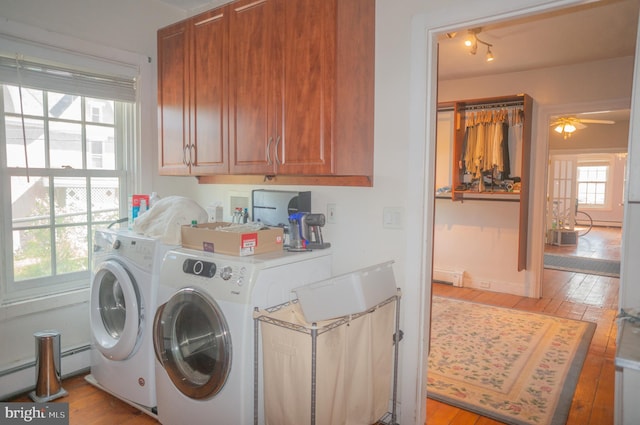 washroom featuring separate washer and dryer, light hardwood / wood-style flooring, cabinets, and a baseboard radiator