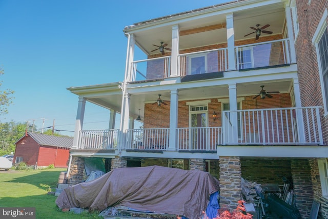 rear view of house with covered porch, a balcony, and a yard