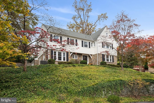 view of front facade featuring a front lawn and central air condition unit