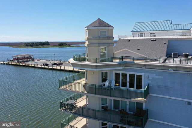 exterior space with central AC, a balcony, and a water view