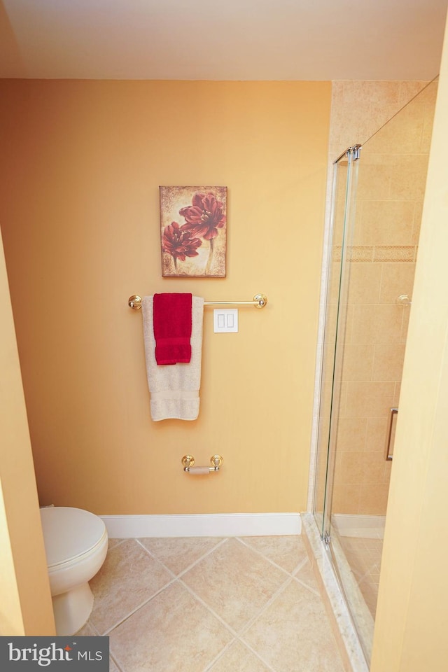 bathroom with a shower with door, toilet, and tile flooring