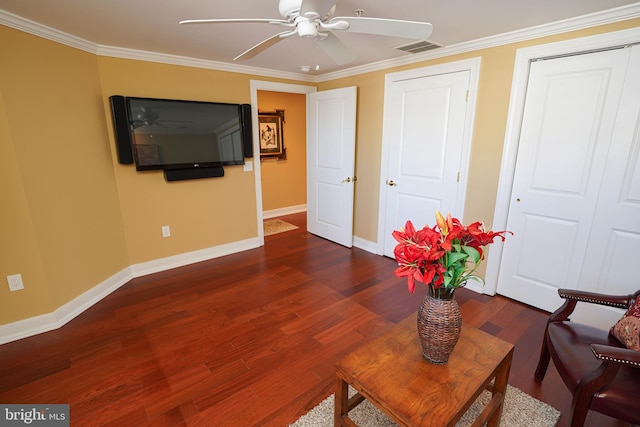 living room with crown molding, dark wood-type flooring, and ceiling fan