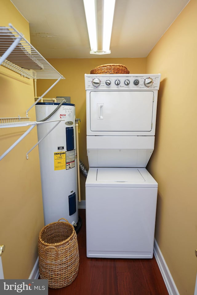 washroom featuring hardwood / wood-style floors, water heater, and stacked washing maching and dryer