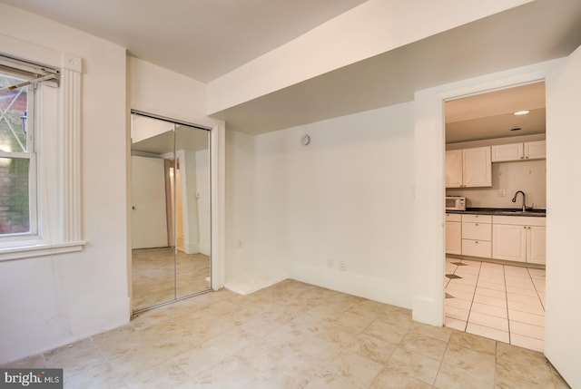 empty room with light tile patterned flooring and sink