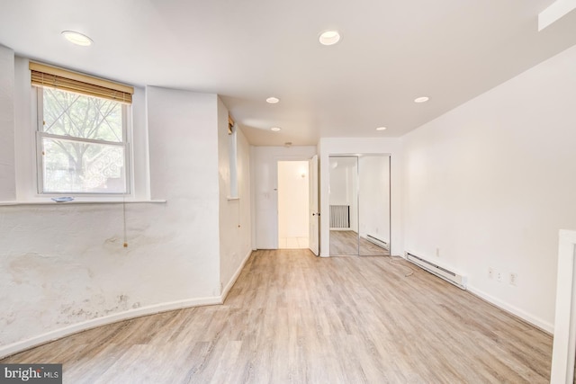 spare room featuring light hardwood / wood-style flooring and a baseboard radiator