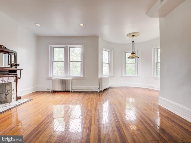 unfurnished living room with light wood-type flooring and radiator heating unit