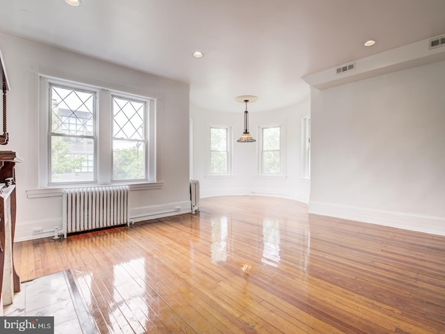 unfurnished living room featuring light hardwood / wood-style flooring and radiator