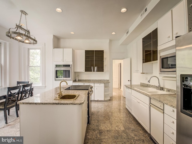 kitchen with white cabinets, sink, an island with sink, and appliances with stainless steel finishes