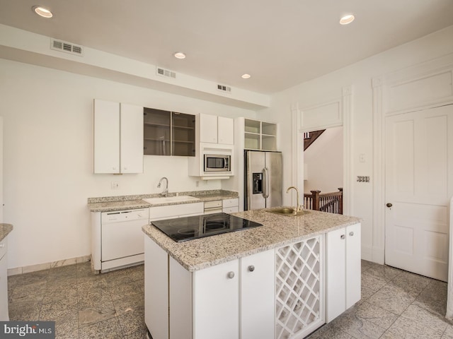 kitchen with sink, white cabinets, a center island with sink, and appliances with stainless steel finishes