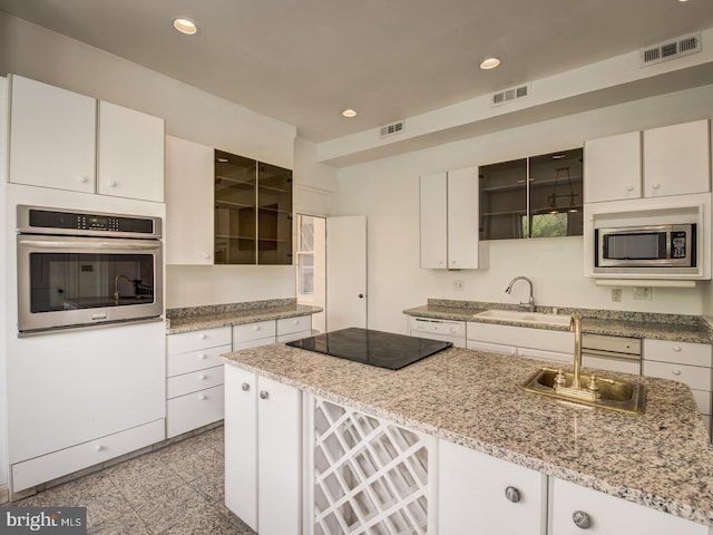 kitchen with sink, white cabinets, and appliances with stainless steel finishes