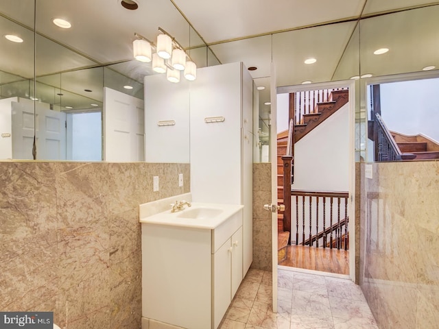 bathroom with vanity and tile walls