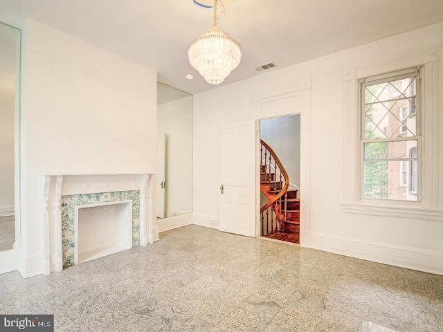 unfurnished living room featuring a wealth of natural light and an inviting chandelier