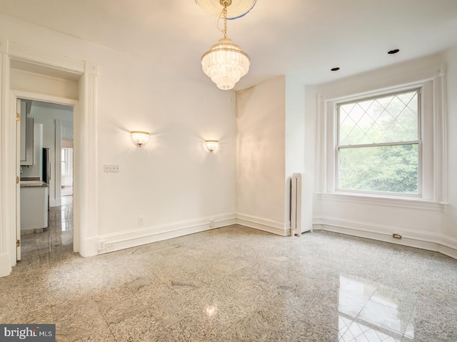 empty room with radiator and a chandelier