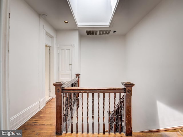 hall featuring a skylight and hardwood / wood-style floors