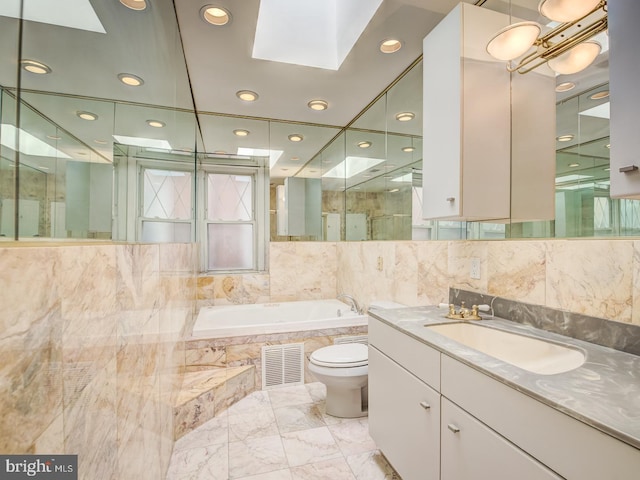 full bathroom featuring a skylight, toilet, vanity, and shower with separate bathtub