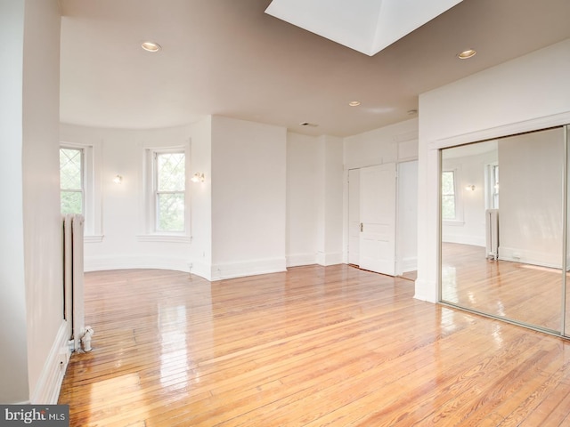 unfurnished room featuring light wood-type flooring and radiator