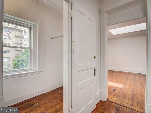 hall with a skylight and hardwood / wood-style flooring