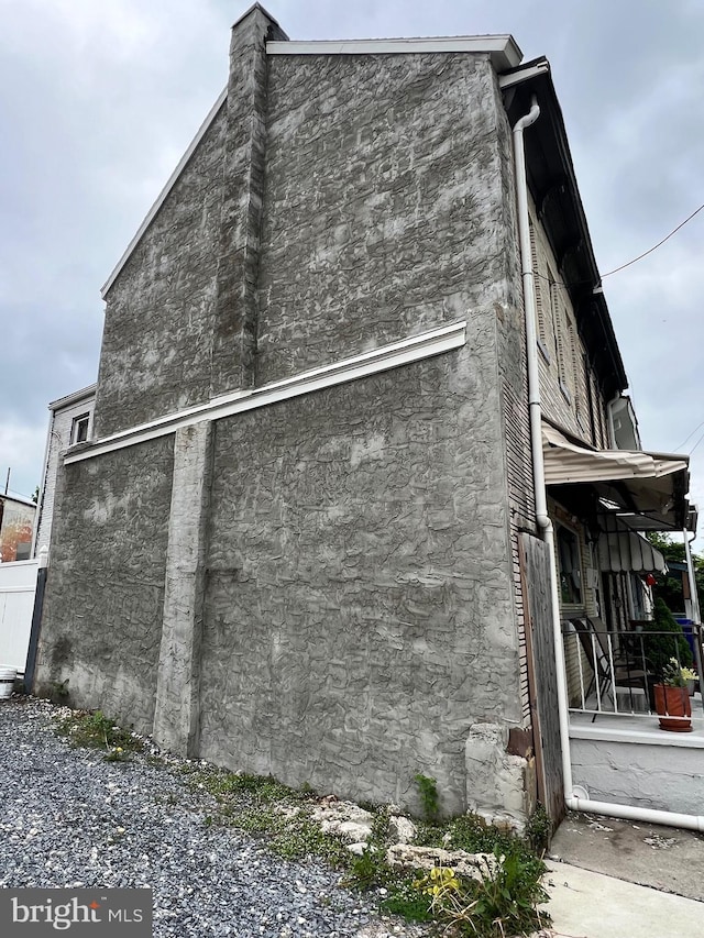 view of side of property featuring a porch and stucco siding