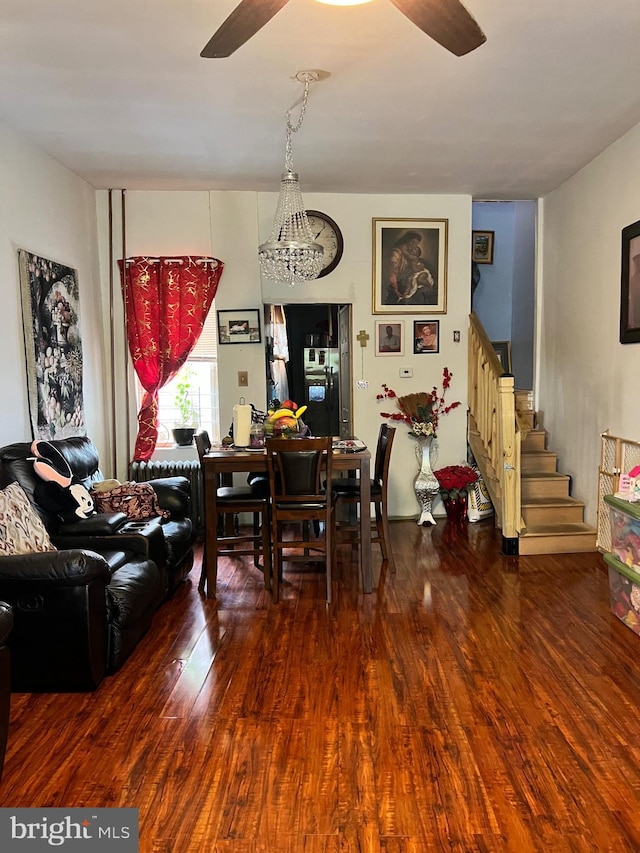 dining area featuring dark wood-type flooring, ceiling fan, and stairway