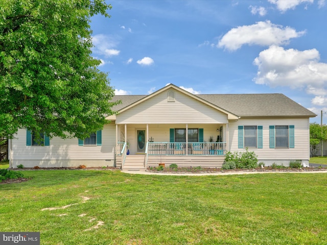 ranch-style house featuring covered porch and a front yard