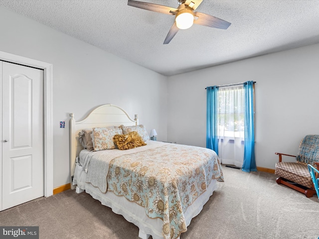 carpeted bedroom featuring ceiling fan, a closet, and a textured ceiling