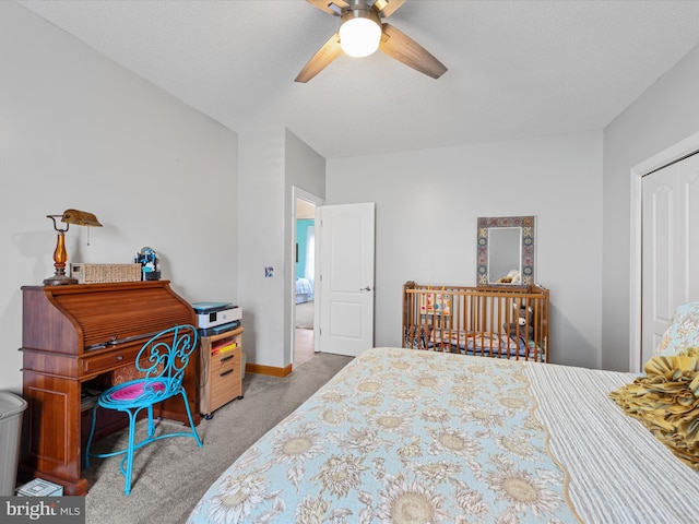 bedroom with a textured ceiling, ceiling fan, light carpet, and a closet