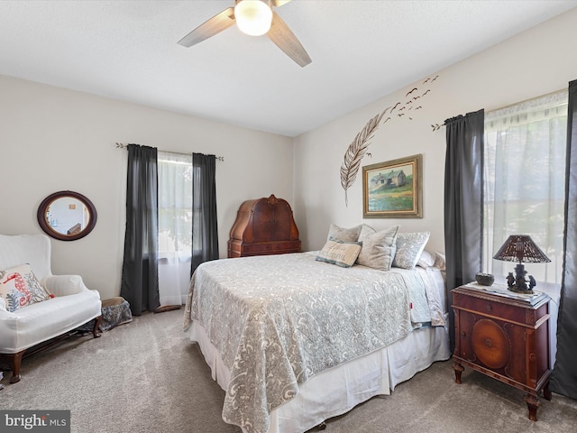 carpeted bedroom featuring multiple windows and ceiling fan