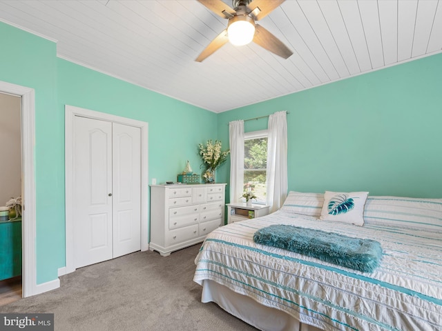 bedroom with ceiling fan, a closet, light colored carpet, and wooden ceiling