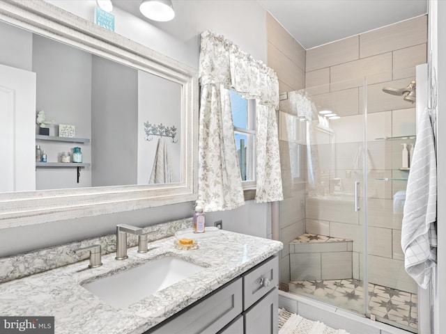 bathroom featuring tile patterned floors, a shower with door, and vanity